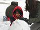 Christine Nguyen, three years old, and her mom are building the snow man.